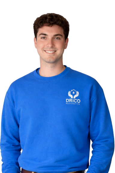 Ben Wallace From Drico Restoration, Smiling In A Blue Sweatshirt, Specializing In Water Damage And Mold Restoration Services.