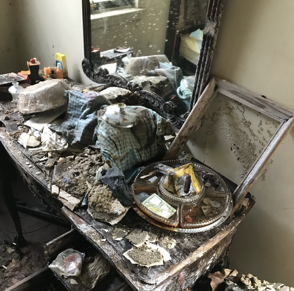 A Shattered Mirror Lies On A Table Alongside Assorted Objects, Depicting A Chaotic Arrangement.