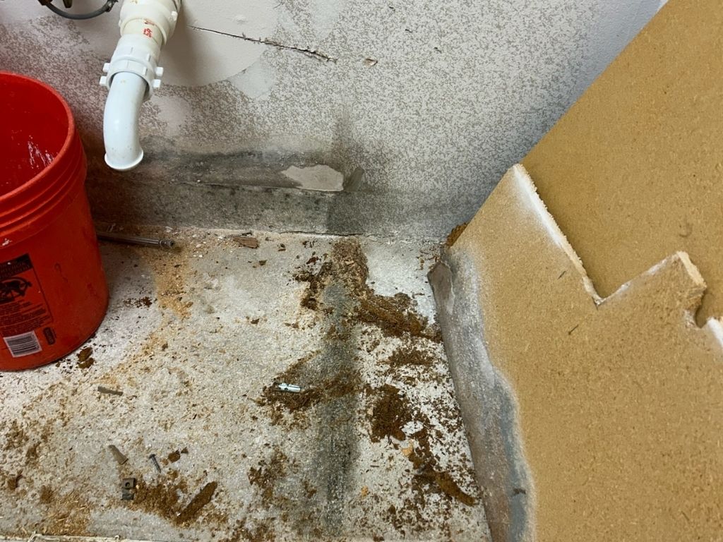 Sewage Damage Under A Sink, Showing Contaminated Materials And Water Stains, Emphasizing The Need For Professional Cleanup And Restoration.
