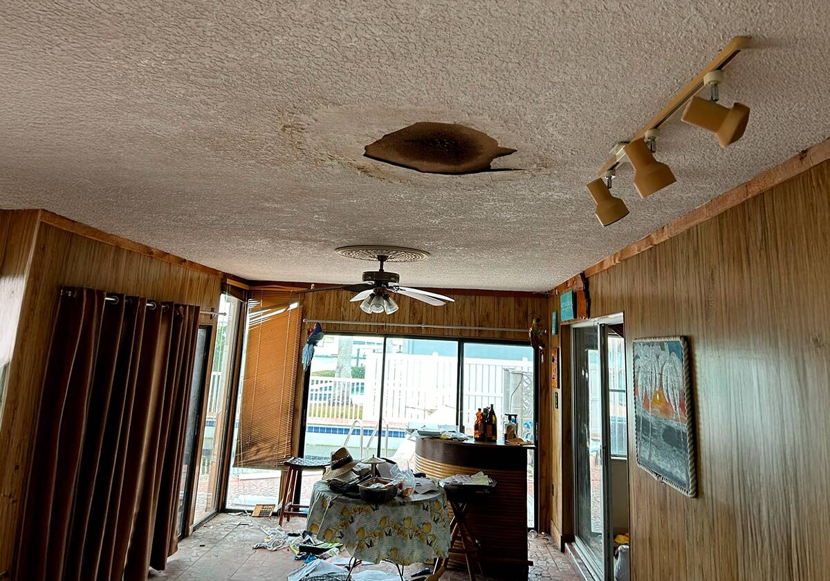 A Ceiling Featuring Multiple Holes And A Corresponding Hole In The Adjacent Wall, Highlighting Structural Damage.