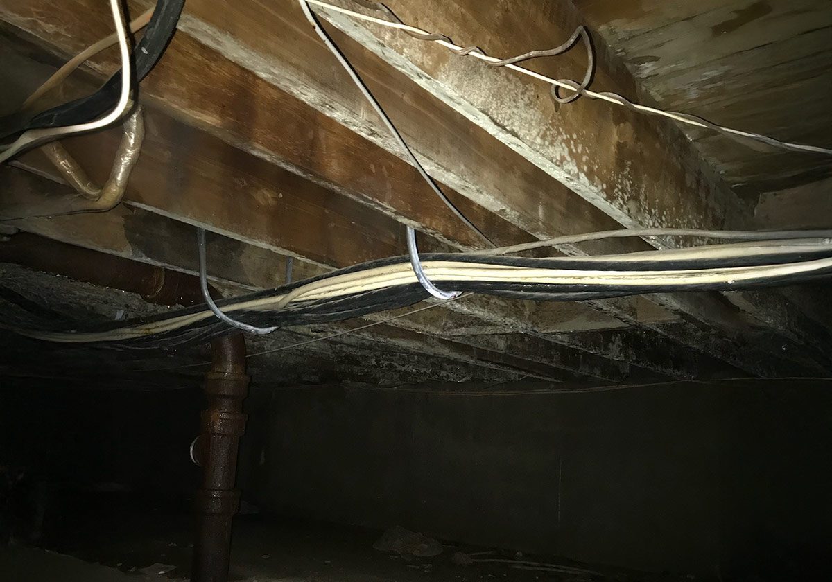 A Cluttered Room Filled With Various Wires And Pipes, Showcasing An Industrial And Utilitarian Environment.