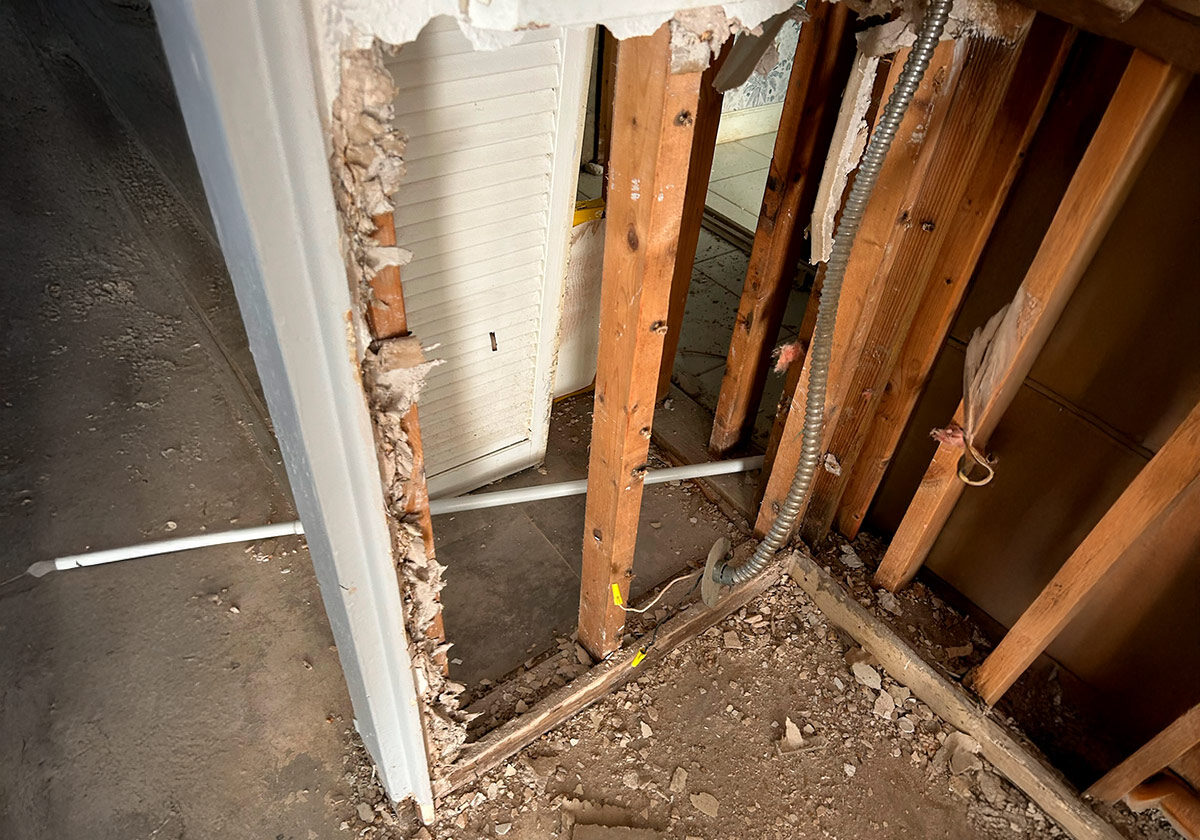 An Open Door Is Being Forcefully Torn Apart, Showcasing Splintered Wood And A Chaotic Scene Of Destruction.